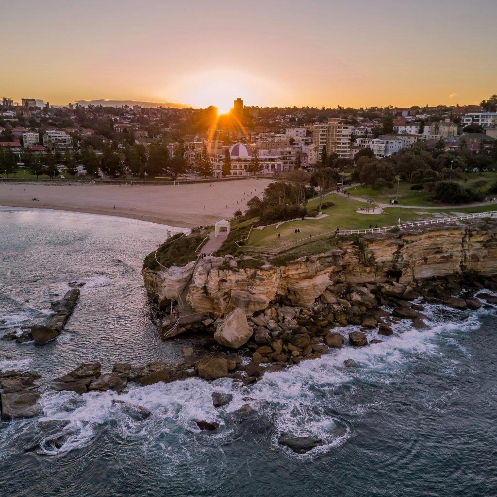 Stunning aerial view of Coogee Beach, Sydney at sunset, showing vibrant coastal scenery.